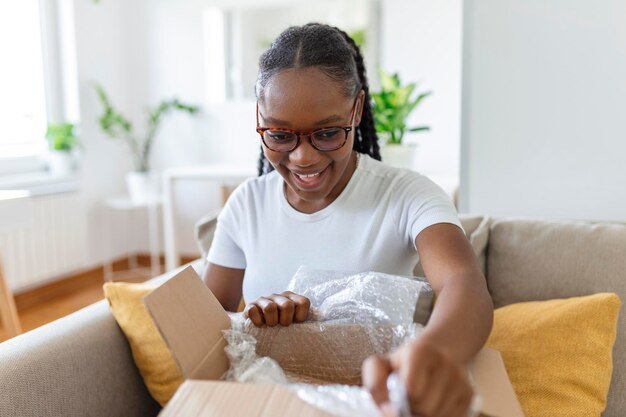 young-satisfied-happy-african-girl-woman-lady-shopaholic-customer-sit-sofa-unpack-parcel-delivery-box-online-shopping-shipment-concept_657921-995.jpg