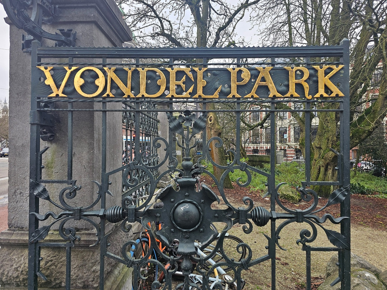 Vondelpark entrance gate with ornate ironwork and gold lettering in Amsterdam.