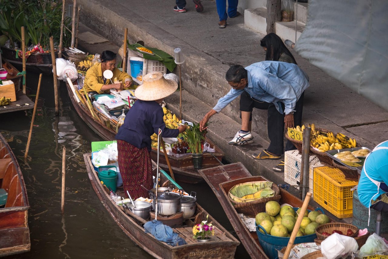 https://www.thenomadicpeople.com/wp-content/uploads/2014/11/Locals-buying-goods-at-Damnoen-Saduak-Floating-Market.jpg