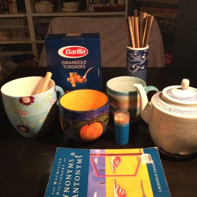 Blue things - 3 different tea cups, a tea pot, a vase with chop sticks, a cardboard box of pasta, a plastic tub with toothpicks, and The MacMillan Dictionary of Synonyms and Antonyms