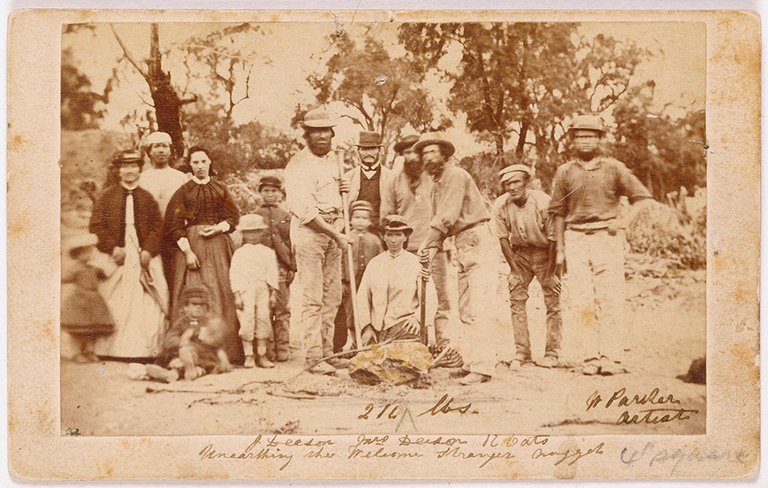 John Deason and Richard Oates posing with their families and fellow miners