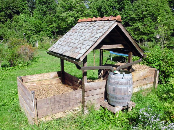 Jenkins' compost bin castle. Notice the sloped roof and water barrel for rainwater harvesting.