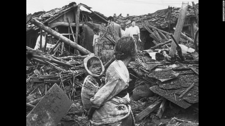 A woman and child wander among debris in Pyongyang, North Korea, after an air raid by U.S. planes, circa 1950. The war began on June 25, 1950, when the North Korean People's Army crossed the 38th parallel and easily overwhelmed South Korean forces in a surprise attack. 