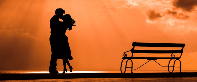 Silhouettes of couple kissing on the beach