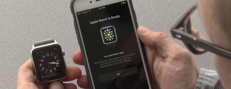 mobile millennium, picture of a man holding the apple watch next to the iphone and syncing them together, bad websites arent mobile friendly