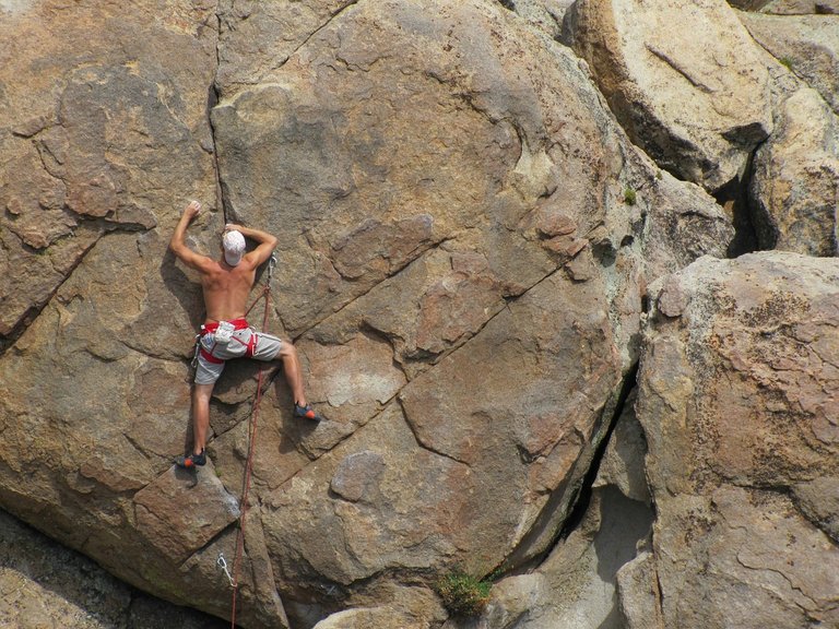 extreme mountain climber climbing a sheer cliff face