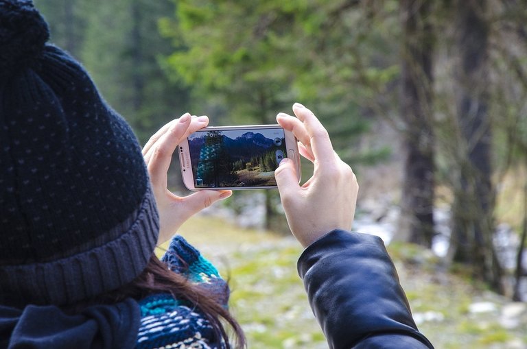 A person takes a photo using her Samsung phone