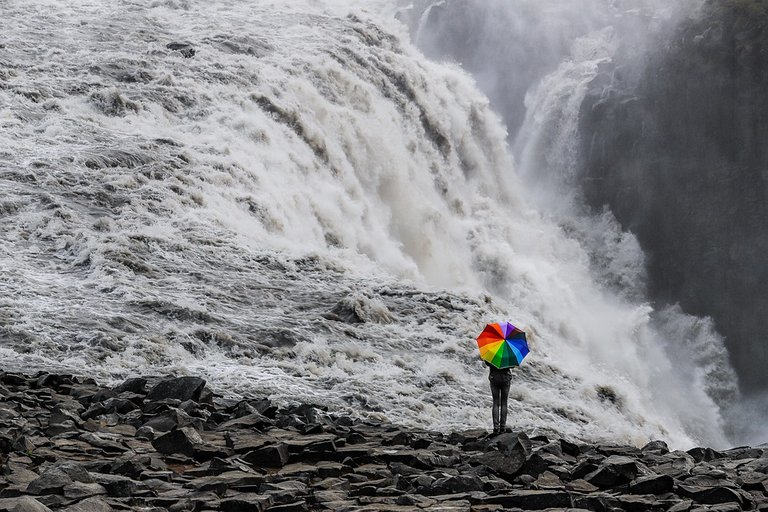 Persona con sombrilla en cascada