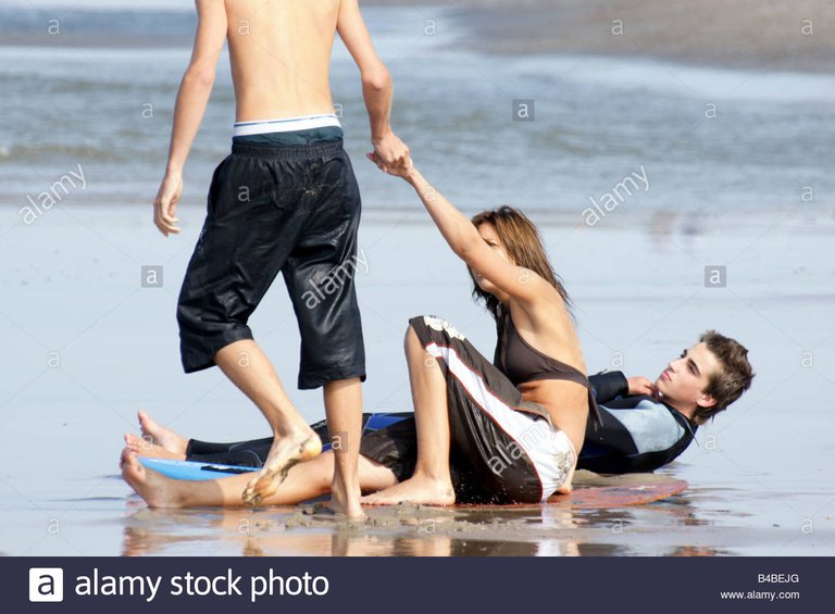 young-man-woman-teenage-girl-boy-bare-feet-beach-shallow-water-sea-B4BEJG.jpg