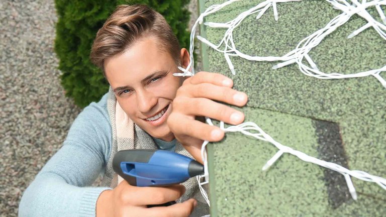 young-man-hanging-christmas-lights-on.jpg