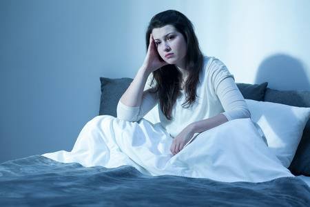 62745719-shot-of-a-sad-young-woman-sitting-on-her-bed-in-the-middle-of-the-night.jpg