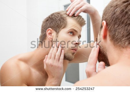 stock-photo-man-standing-in-front-of-mirror-worrying-about-hair-loss-254253247.jpg