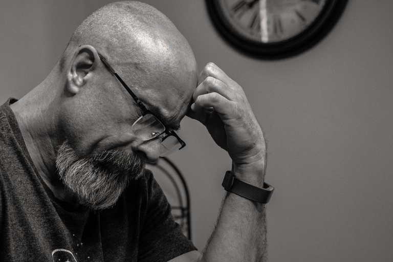 grayscale-photo-of-man-thinking-in-front-of-analog-wall-1194196.jpg