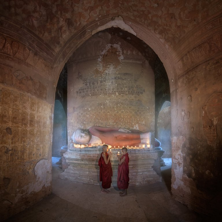 Two Monks Praying Inside Ancient Temple with the Reclining Buddha, Bagan, Myanmar.jpg