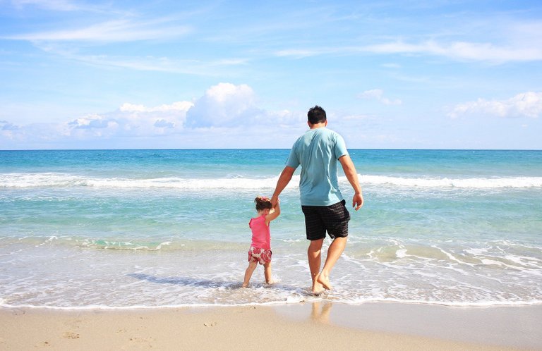 Father with her little daughter on the sea beach.jpg