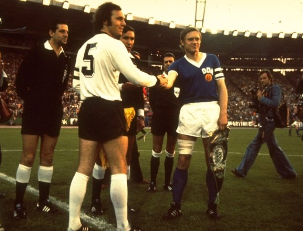 22jun1974---franz-beckenbauer-da-alemanha-ocidental-cumprimenta-bernd-bransch-capitao-da-alemanha-oriental-durante-o-historico-duelo-alemao-na-copa-do-mundo-de-1974-em-hamburgo-1530299205996_615x470.jpg