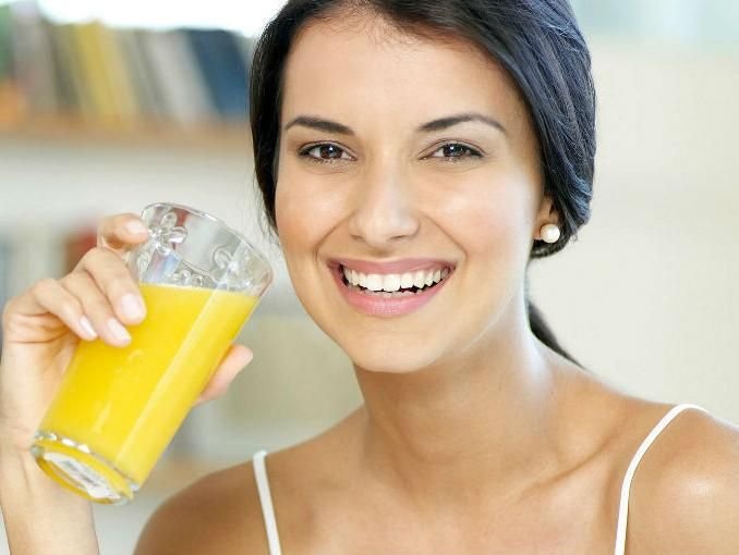 mujer tomando naranja.jpg