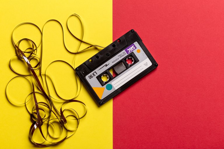 black-cassette-tape-on-top-of-red-and-yellow-surface-1626481.jpg