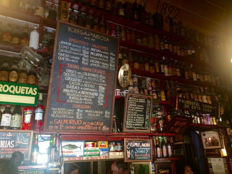 5 Bottles signs and other stuff behind the bar in Bodega de la Ardosa.jpg