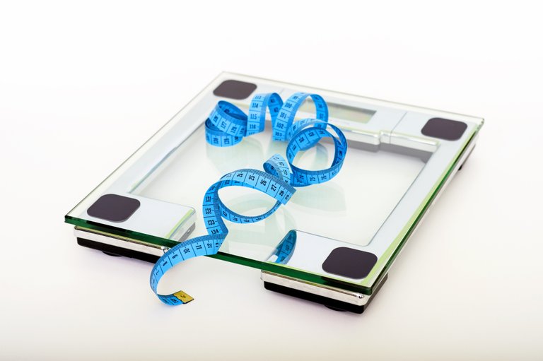 blue-tape-measuring-on-clear-glass-square-weighing-scale-53404.jpg