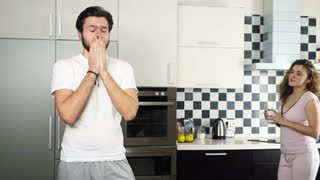 wife-bringing-a-cup-of-coffee-to-his-sleepy-husband-in-the-kitchen-slow-motion_4df23wykx__S0000.jpg