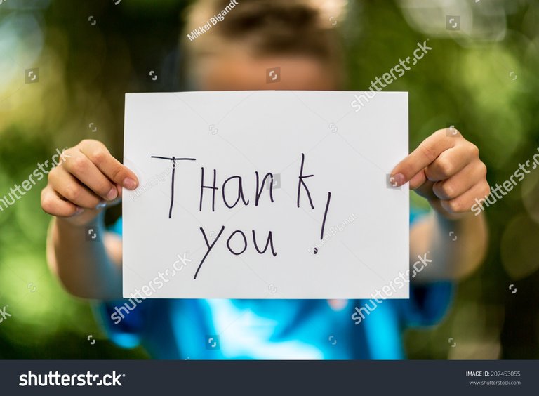 stock-photo-blurred-boy-holding-a-piece-of-paper-with-the-words-thank-you-in-front-of-her-207453055.jpg