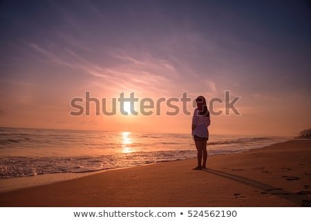 lonely-woman-standing-on-beach-450w-524562190.jpg