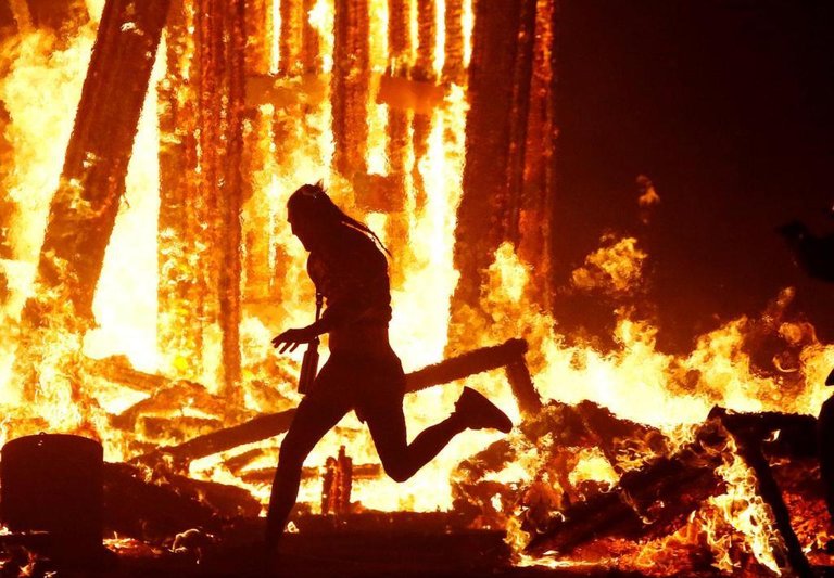 Burning-Man-participant-runs-into-the-flames-of-the-Man-Burn-at-the-Burning-Ma.jpg