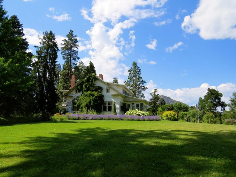 house-surrounded-by-green-grass-below-clouds-and-sky-226407.jpg