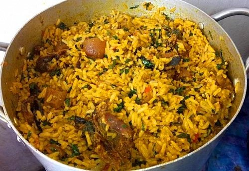 1506550823-Adding-of-leaves-to-palm-oil-jollof-rice-recipe1.jpg