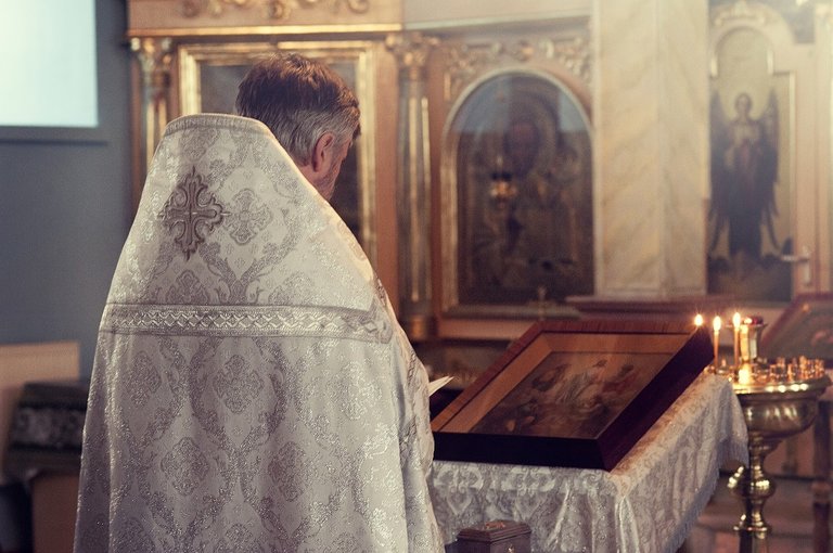 Sacerdote leyendo la biblia en la iglesia