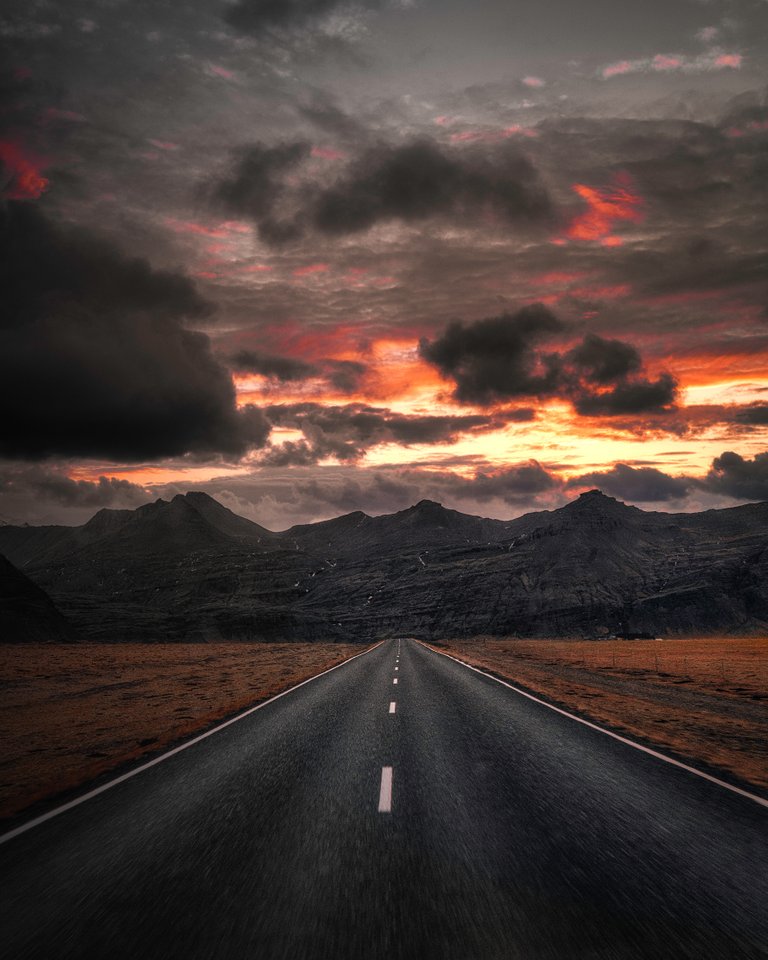 black-asphalt-road-near-mountains-under-cloudy-sky-3733269.jpg