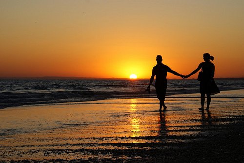 pareja-caminando-playa-atardecer-tomados-mano.jpg