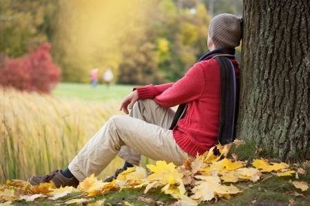 23848247-hombre-triste-que-se-sienta-bajo-el-árbol-de-otoño-en-el-parque.jpg