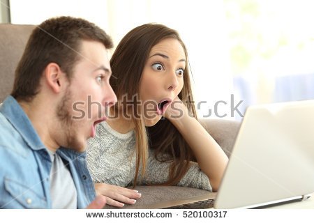 stock-photo-amazed-couple-with-open-mouth-on-line-with-a-laptop-lying-on-a-couch-in-the-living-room-in-a-house-520100317.jpg