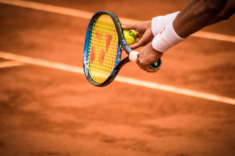 close-up-photo-of-person-holding-tennis-racket-and-ball-1432039.jpg