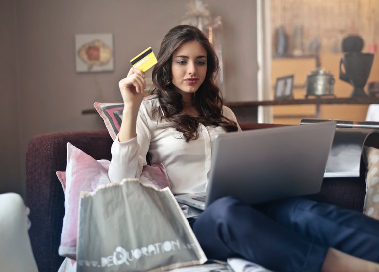 woman-holding-card-while-operating-silver-laptop-919436.jpg