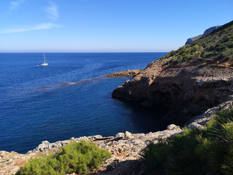 Just before the hike turns into a rock climbing session, the road goes around a small gulf with Cova Tallada almost visible behind the next corner. 