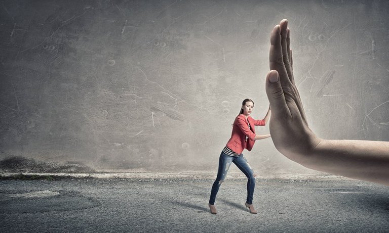 A small lady pushing on a huge hand