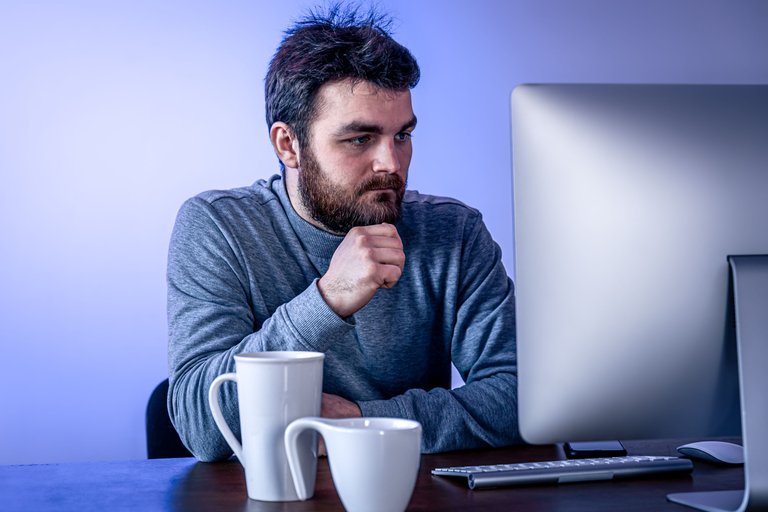 tired-man-sits-in-front-of-a-computer-with-a-cup-o-2022-02-09-07-03-30-utc.jpg