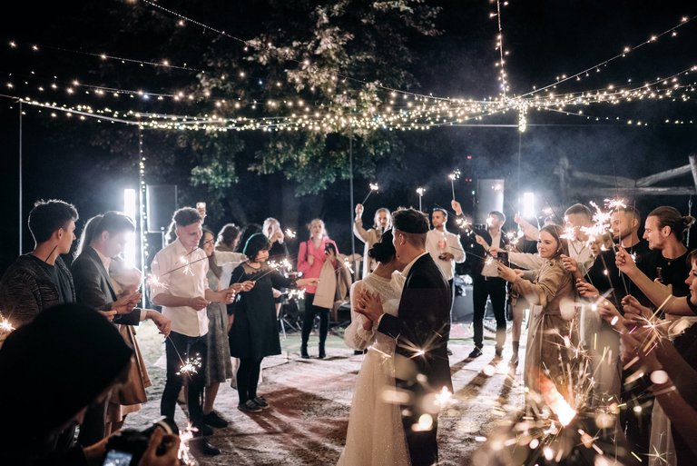 free-photo-of-wedding-guests-holding-sparklers-and-standing-around-the-newlyweds-dancing.jpeg
