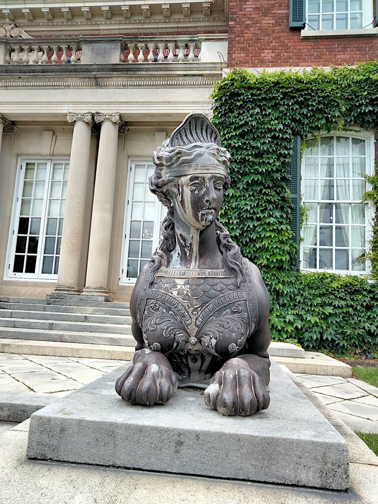 front view woman lion statue old westbury.png