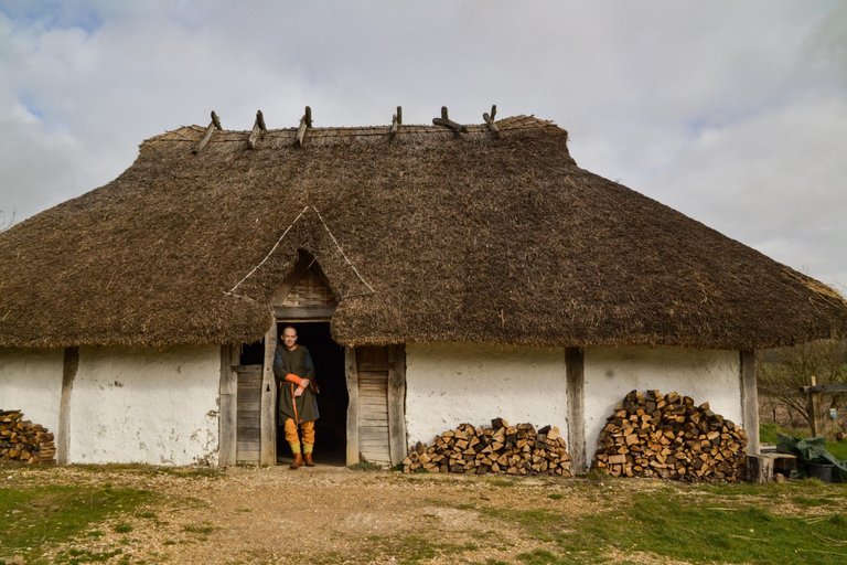 Butser_Ancient_Farm_Saxon_Hall_with_re-enactor_RHB2002 4.0.jpg