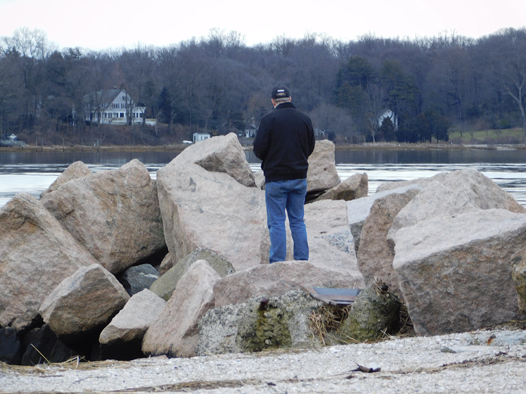 man on rocks oyster bay.png