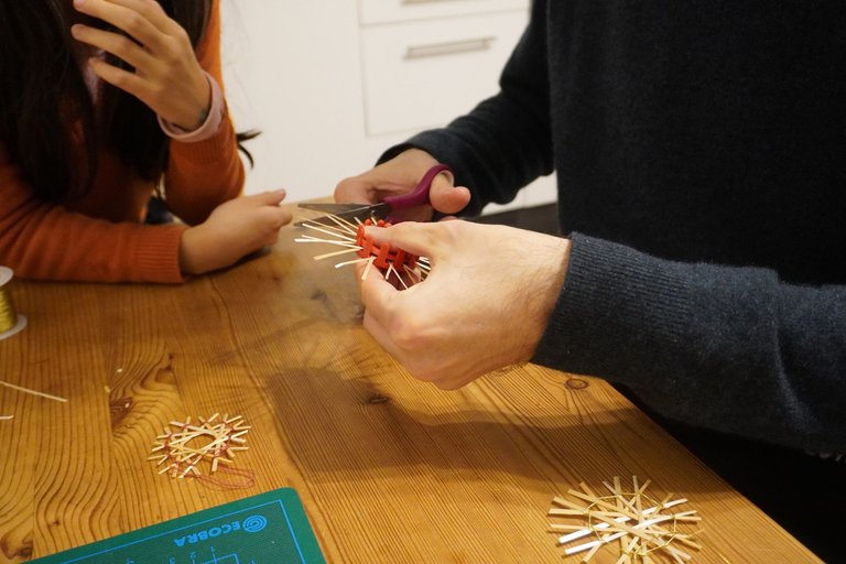 My daughter teaching my partner how to make straw stars