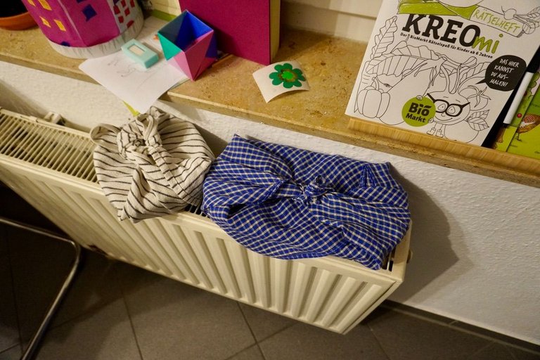 Vegetables in a basket, covered with a cloth, drying over the heater