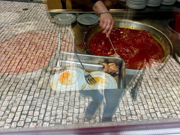 Sliced pork being prepared in the sauce outside the restaurant.