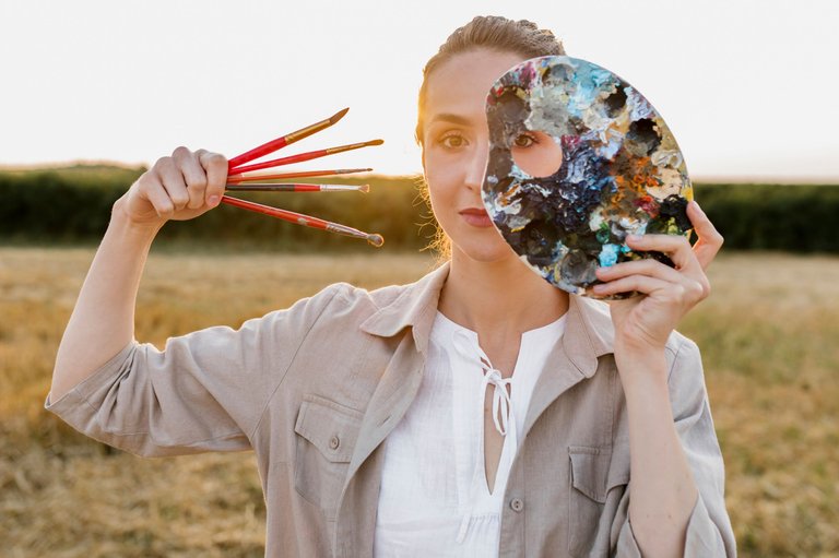 artistic-young-woman-holding-paint-brushes.jpg