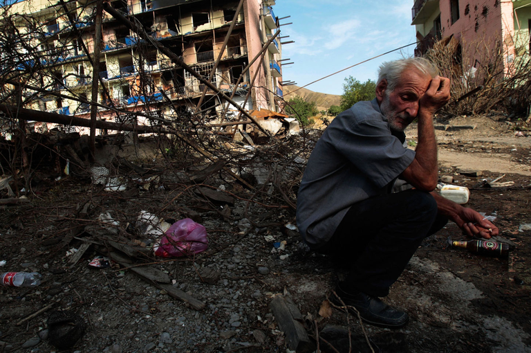 A man in the city of Gori among residential buildings destroyed by russian bombs. Photo: Chris Hondros for Getty Images
