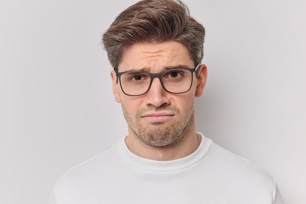 hombre-europeo-adulto-insatisfecho-enfurrunado-mira-tristeza-camara-frunce-ceno-enojo-usa-gafas-transparentes-jersey-casual-aislado-sobre-fondo-blanco-molesto-queja-algo_273609-56830.jpg